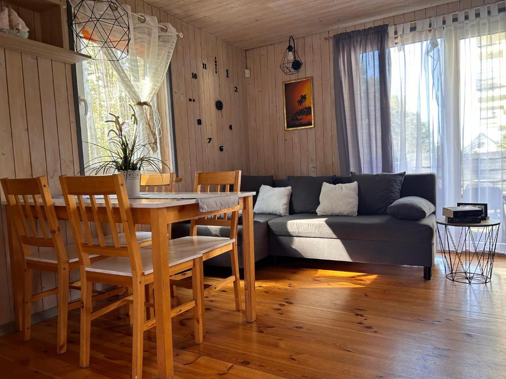 - un salon avec une table et un canapé dans l'établissement Resort EDEN - domki, pokoje, apartamenty, à Jastrzębia Góra