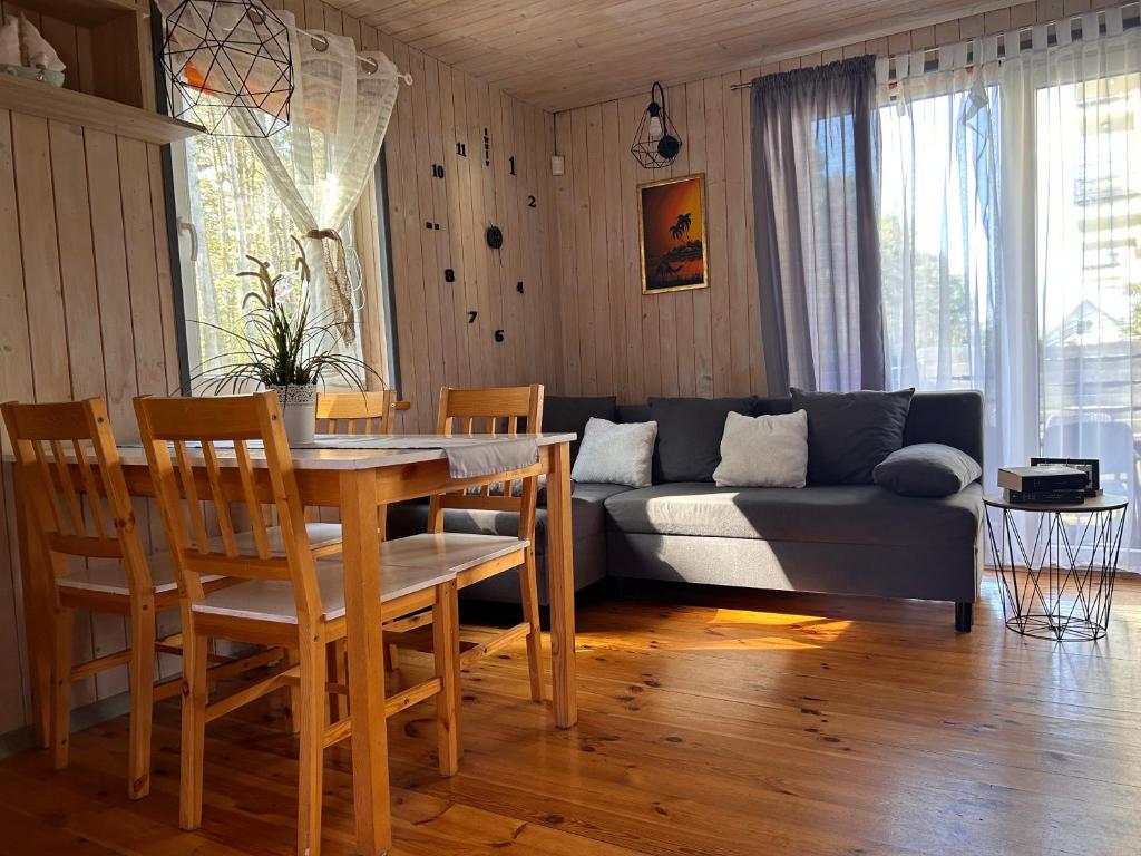 a living room with a table and a couch at Resort EDEN - domki, pokoje, apartamenty in Jastrzębia Góra
