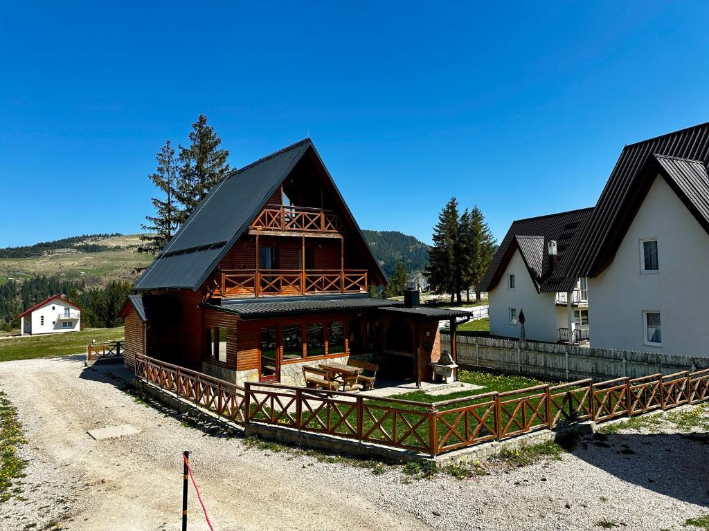 a large log cabin with a house at Holiday home Krajina I in Vlasic