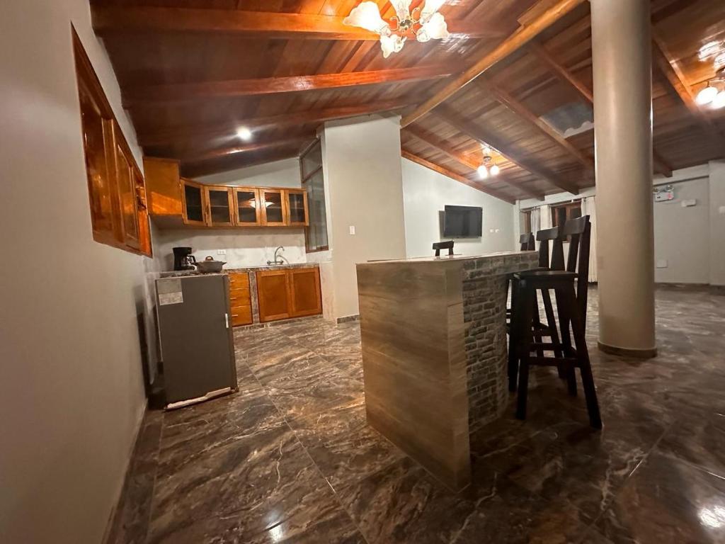 una cucina con bar, sedie e frigorifero di Casa SAMAY OLLANTAYTAMBO a Ollantaytambo