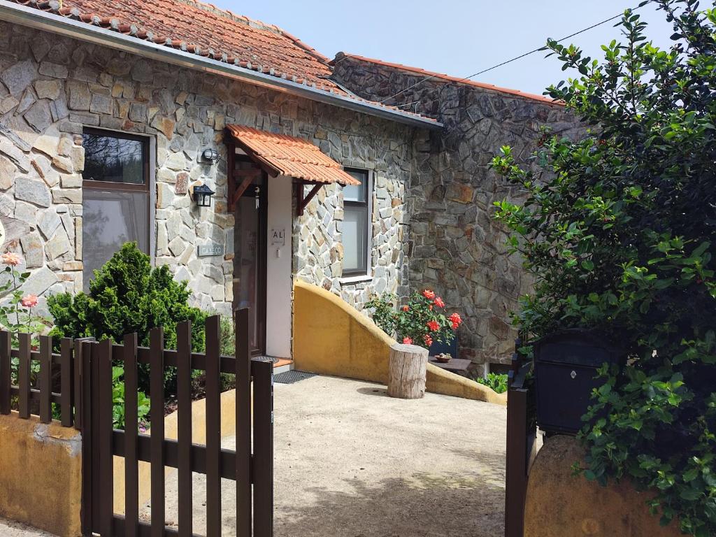 una casa de piedra con una puerta de madera delante de ella en Alojamento Casa do Cabeço Alombada, en Macinhata do Vouga