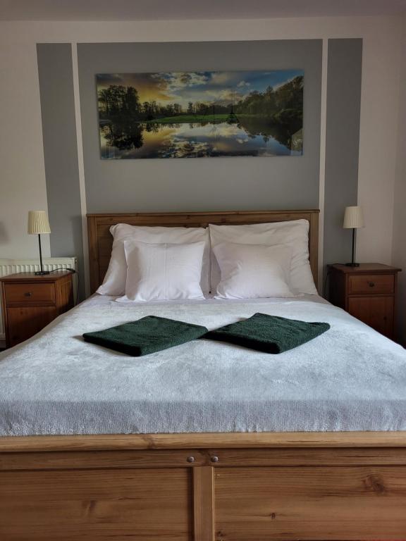 a bed with two green towels on top of it at Apartamenty Amadeus in Stronie Śląskie