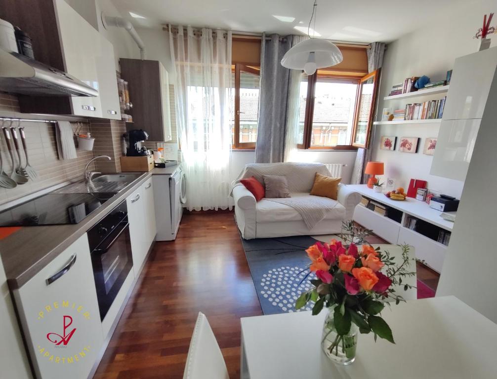 Il comprend une cuisine et un salon avec une table et un canapé. dans l'établissement Premier Apartment Milano, à Milan