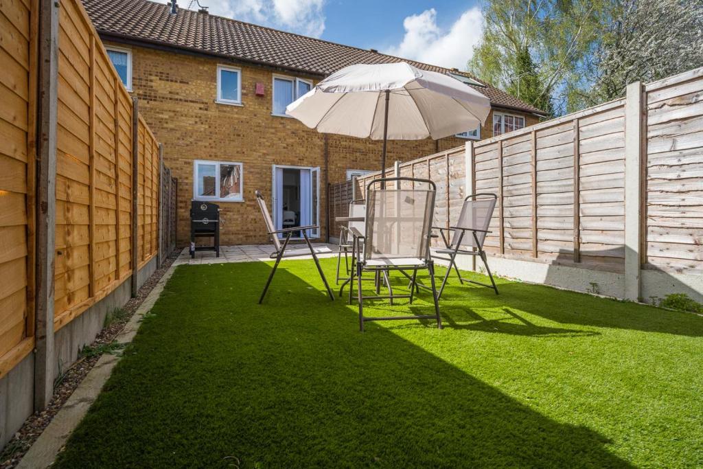 a patio with a table and chairs and an umbrella at Luxurious 2-Bed House in Dartford in Dartford
