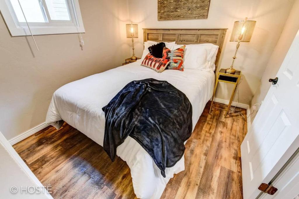 Schlafzimmer mit einem weißen Bett und Holzboden in der Unterkunft Manitou Springs Downtown Escape in Manitou Springs