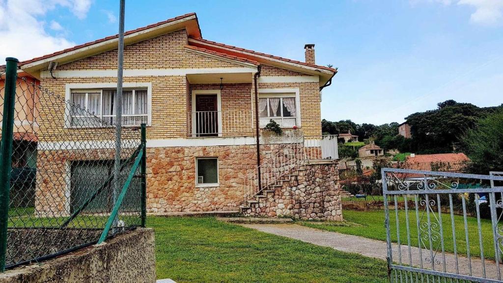 a brick house with a gate in front of it at Casa Vacacional las Tercias in Niembro