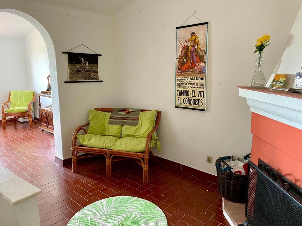 a living room with a green chair and a fireplace at Casa David in Castelo de Vide