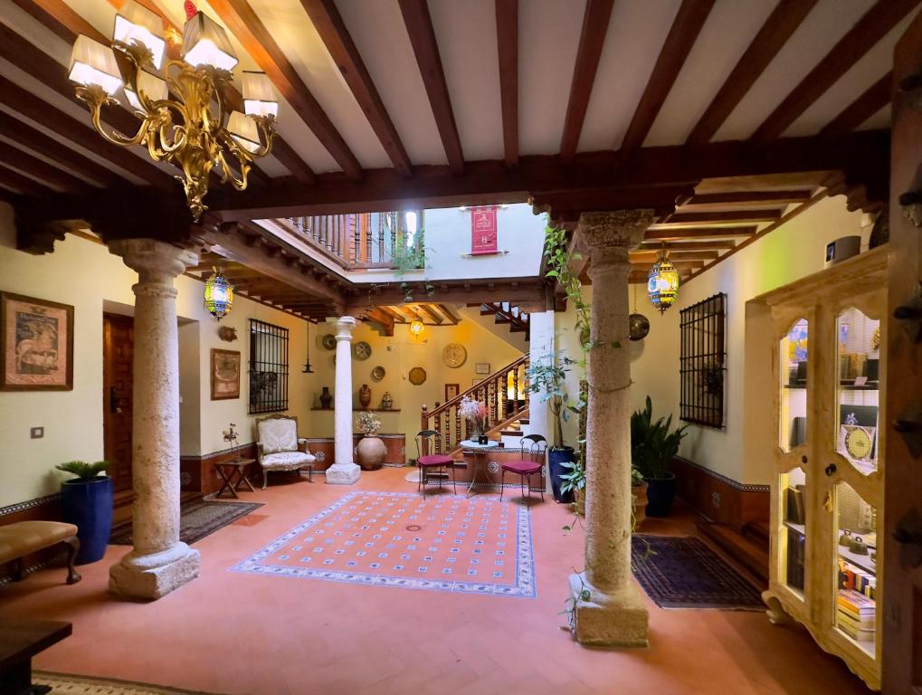 een grote woonkamer met een plafond met een kroonluchter bij Almunia de San Miguel in Toledo