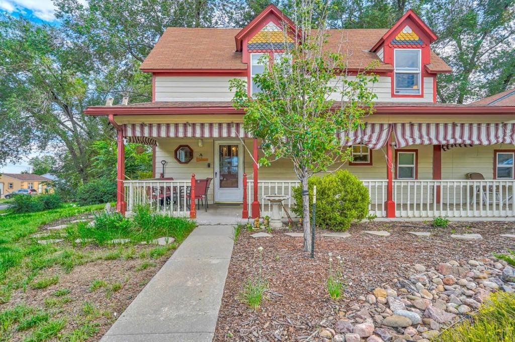 a red and yellow house with a tree in front of it at Charming Victorian Haven Near Garden of the Gods in Colorado Springs