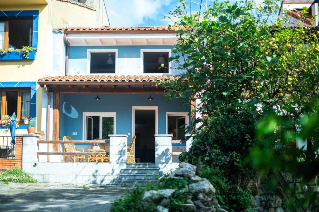a blue house with a staircase in front of it at Villa Selina Llanes – Terraza, Vista y Playa Cerca in La Pereda de Llanes