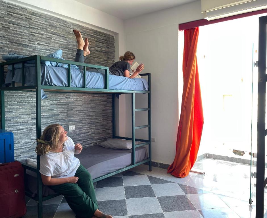 two people sitting on bunk beds in a room at My Hostel in Dahab - Dive center in Dahab