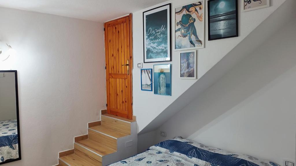 een kamer met een trap met foto's aan de muur bij Casa Schiera Solanas in Solanas