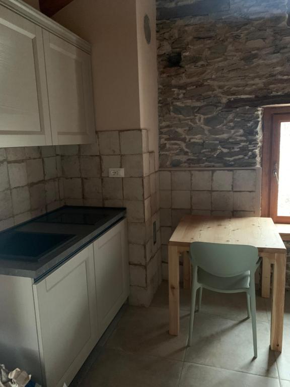 uma cozinha com uma mesa, uma mesa e uma cadeira em Alte terre - Lab&room em San Damiano Macra