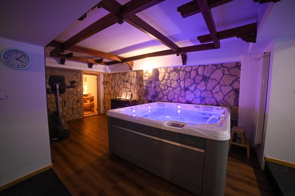 uma cozinha com uma banheira com iluminação roxa em No 107 Predeal em Predeal