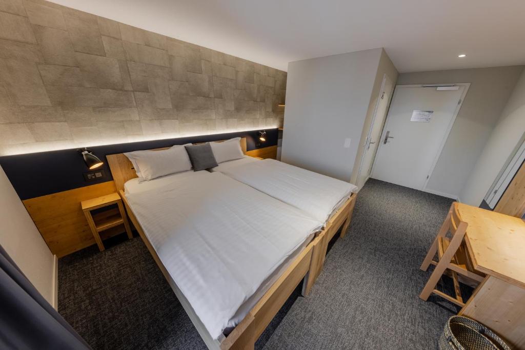a bedroom with a large white bed in a room at Villars Lodge in Villars-sur-Ollon