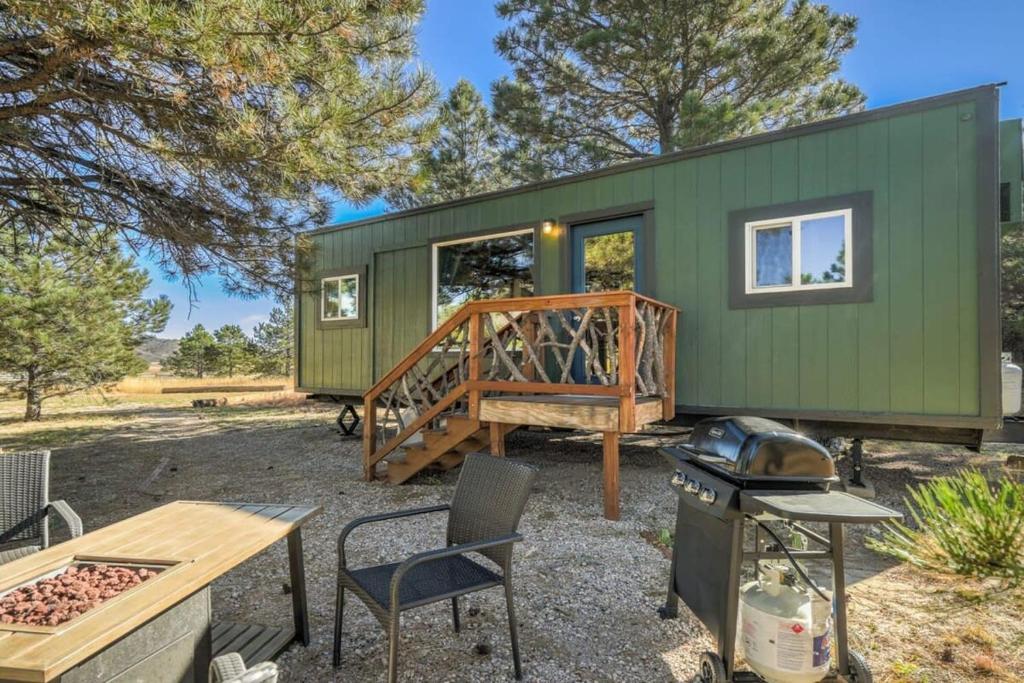 una casita verde con una mesa de picnic y una parrilla en Prairie Place, en Palmer Lake