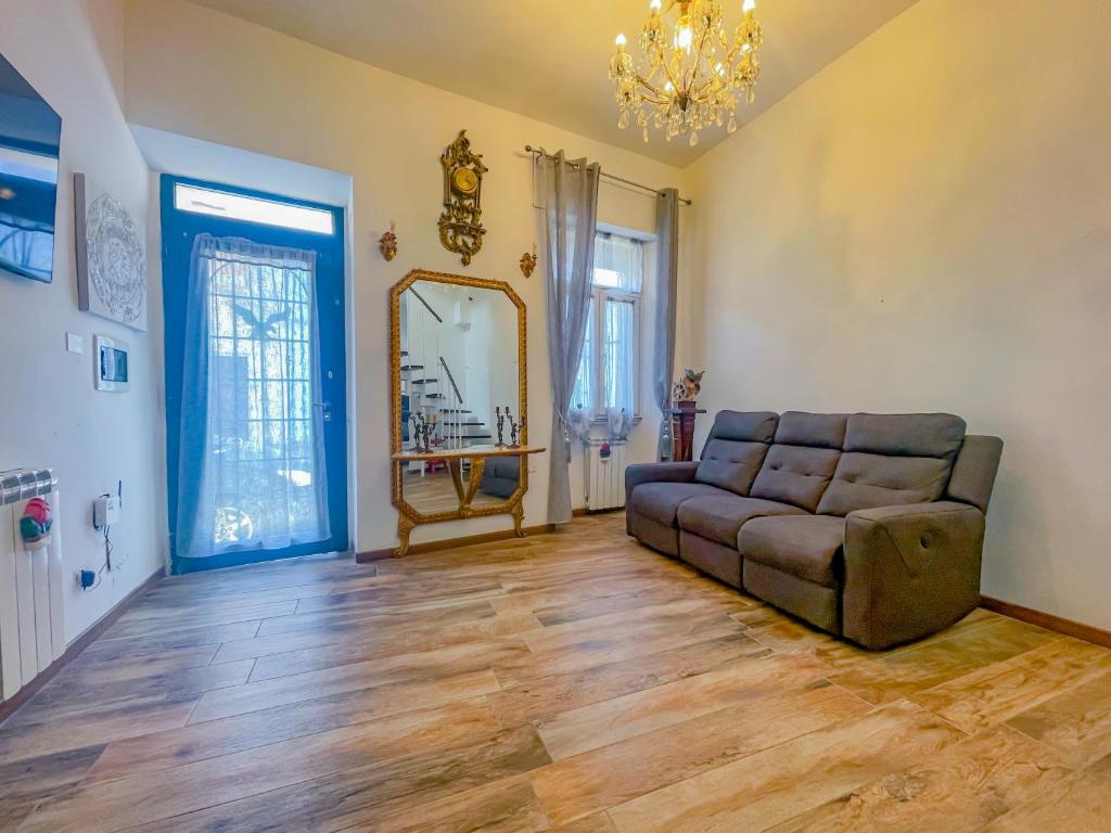 sala de estar con sofá y espejo en Centralissima con 7 posti letto en Nettuno