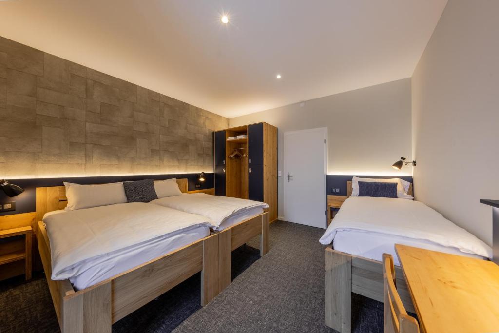 a bedroom with two beds and a table and chairs at Villars Lodge in Villars-sur-Ollon