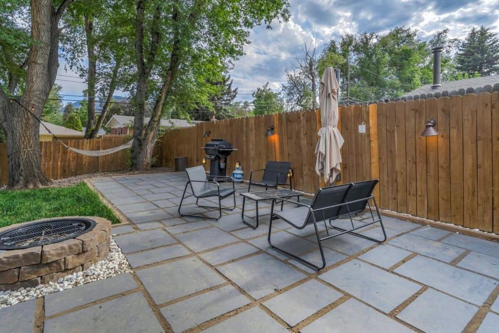 a patio with chairs and a grill and a fence at Family Oasis Offices Home Gym Fenced Yard in Colorado Springs