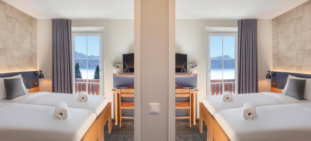 two beds in a room with two windows at Villars Lodge in Villars-sur-Ollon
