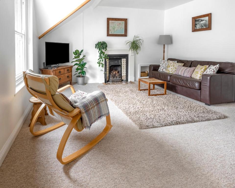 a living room with a couch and a chair at Apartment in the heart of Beer on Jurassic Coast in Beer