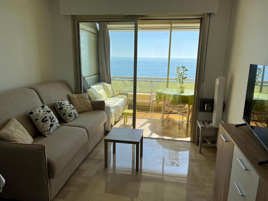 un soggiorno con divano e vista sull'oceano di Azur Bleu a Villeneuve-Loubet