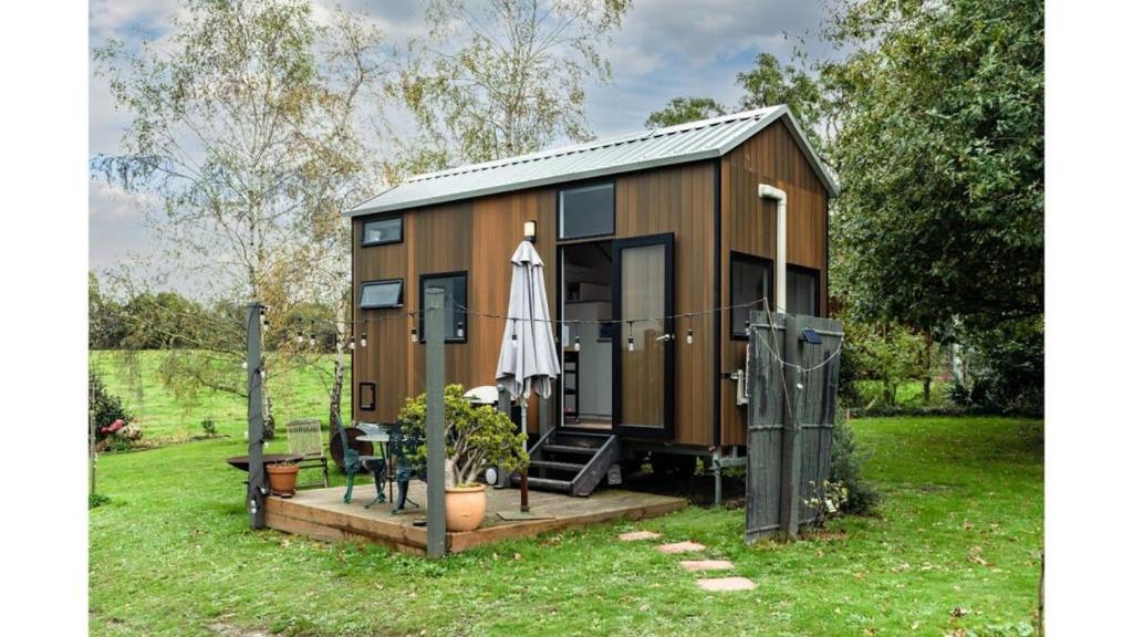 Cette petite maison dispose d'une terrasse et d'un parasol. dans l'établissement Wodalla Horse Farmstay, à Nyora