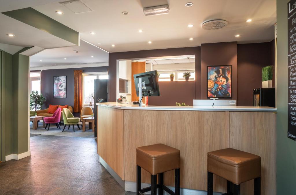 a bar with two stools and a tv above it at Thon PartnerHotel Storgata in Kristiansund
