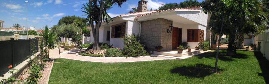 a large white house with a yard with green grass at Villabeni in Benicàssim