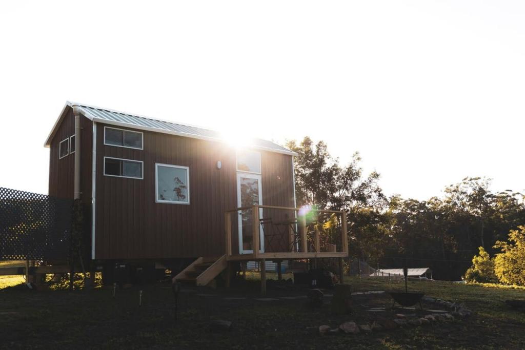 Una casetta è seduta in un giardino di Kookaburra Cabin a Palmwoods