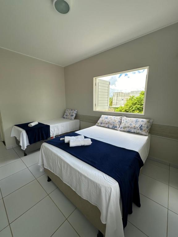 2 camas en una habitación con ventana en Casa Barra de São Miguel - AL, en Barra de São Miguel