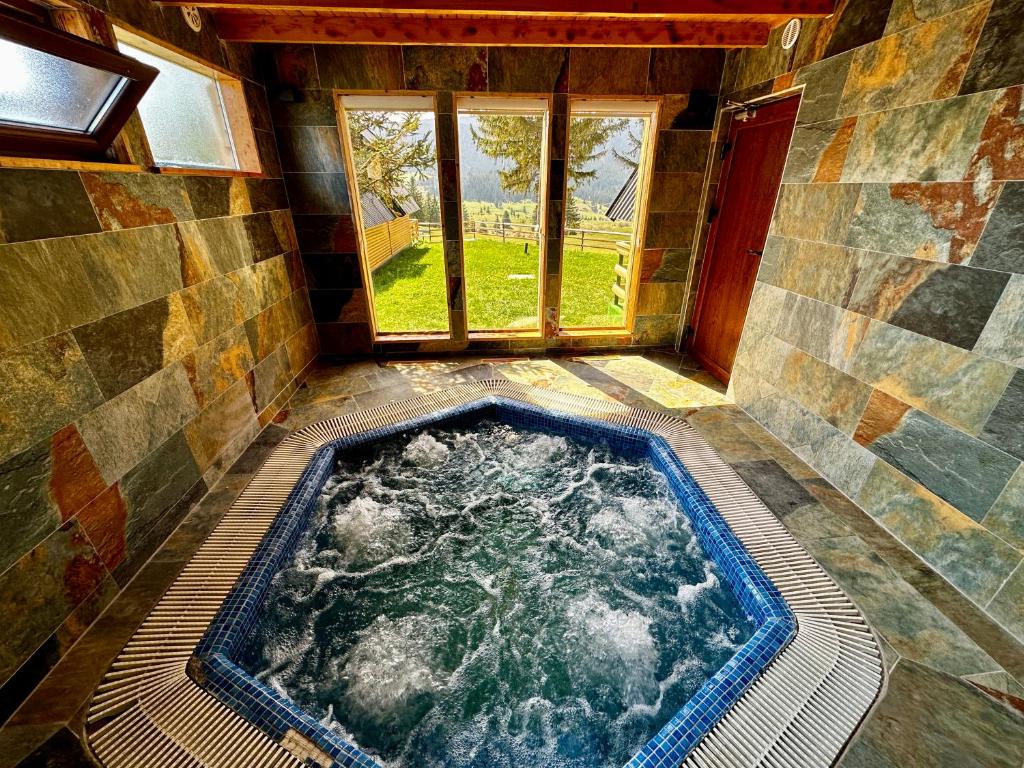 a hot tub in a room with a window at Krajina IV & jacuzzi in Vlasic