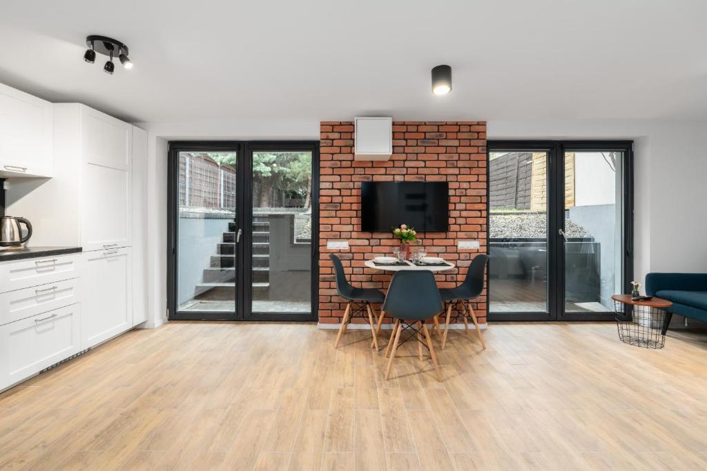 a kitchen and living room with a brick wall at Modern Studio with Terrace and Garden by Renters in Poznań