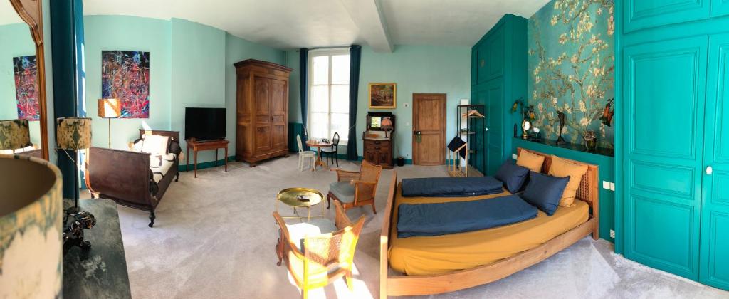 a living room with blue walls and a bed at Le Grand Barrois in Crecy la Chapelle