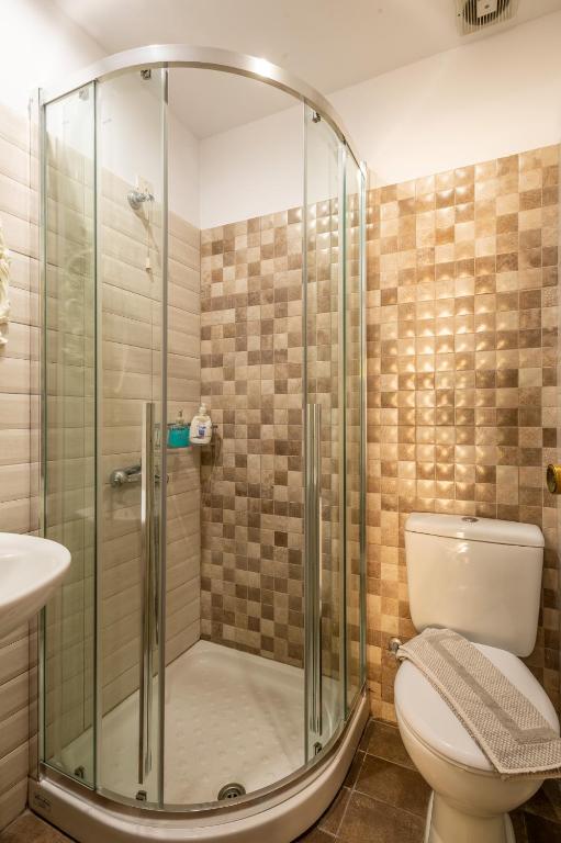 a bathroom with a shower with a toilet and a sink at Fantastic Matala 1 in Matala