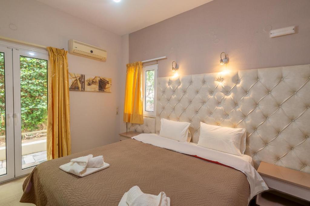 a bedroom with a large bed and a large window at Fantastic Matala 1 in Matala