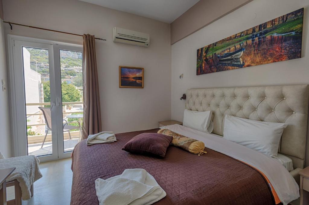 a bedroom with a large bed with a large window at Fantastic Matala 1 in Matala