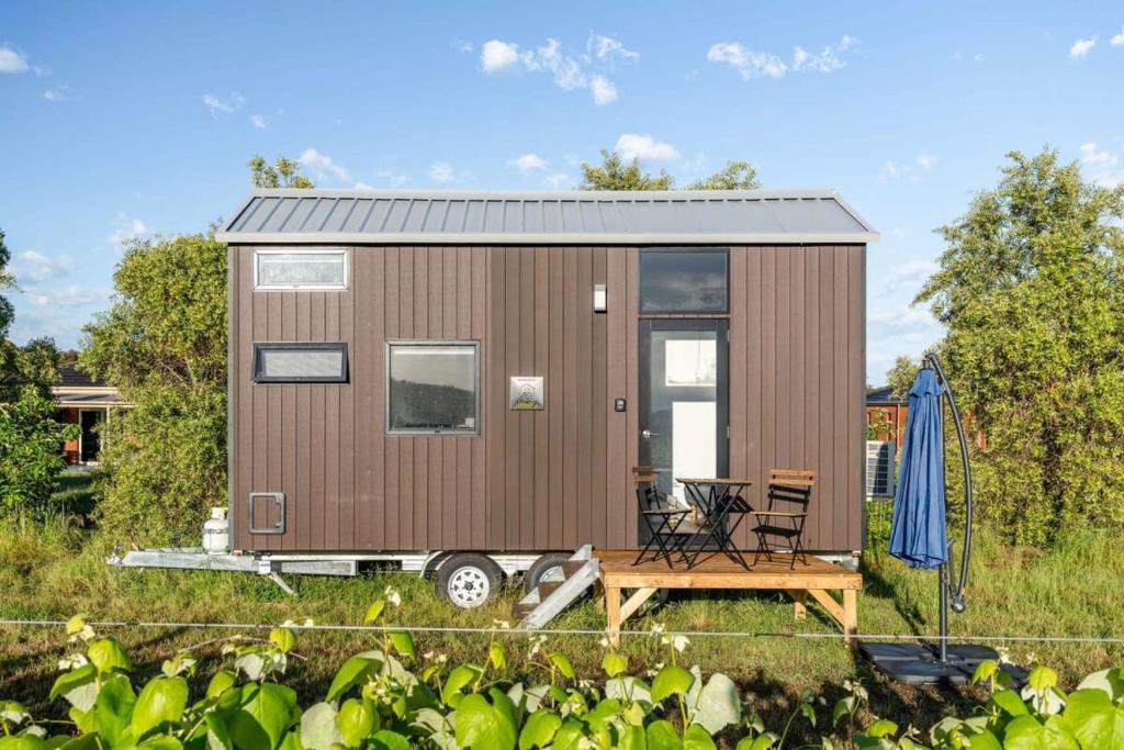 a tiny house with a deck and a patio at Vineyard Retreat in Toolleen