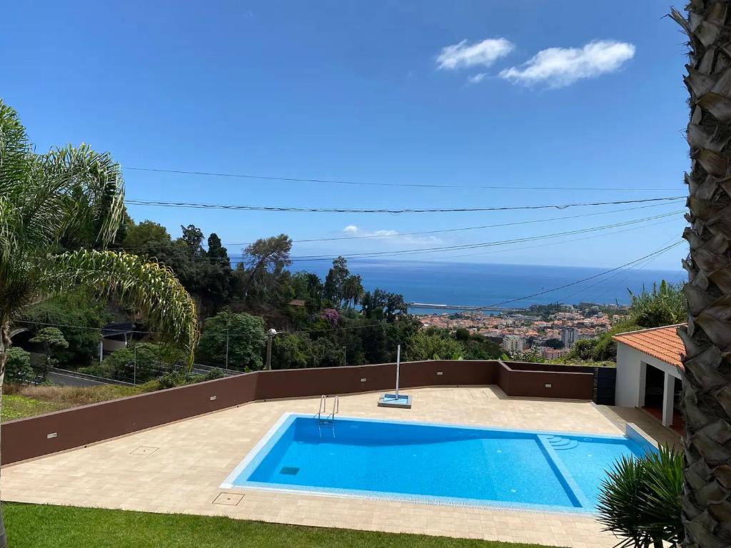 una piscina con vistas al océano en Hillside Haven: Elegant Modern 2 BR Condo w/ Pool, en Funchal