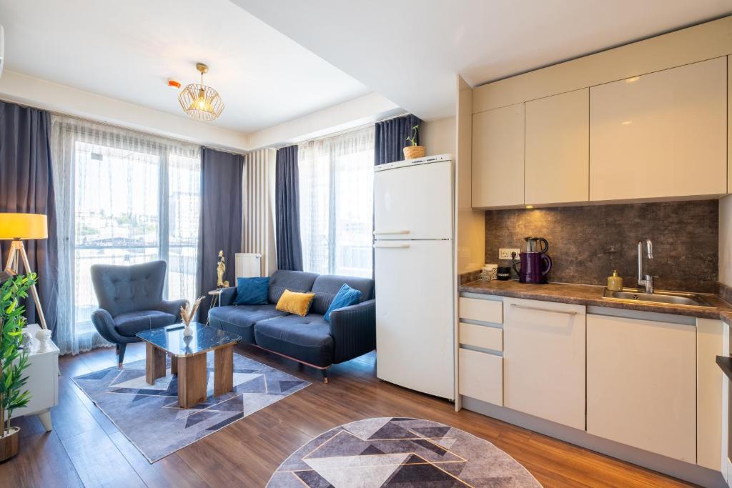 Una cocina y una sala de estar con un sofá y una mesa. en PlusHome Residence İstanbul, en Estambul