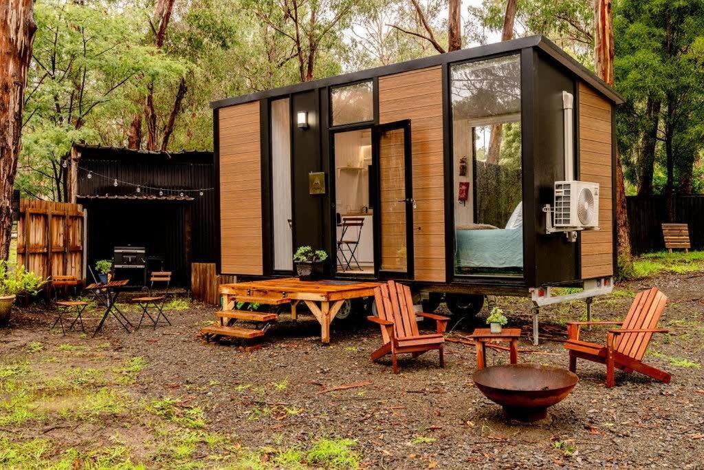 a tiny house with a wooden table and chairs at Mountain Ash Cabin 