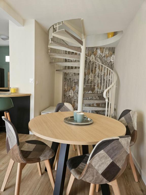 een eetkamer met een houten tafel en stoelen bij Le cosy duplex centre in Dinan