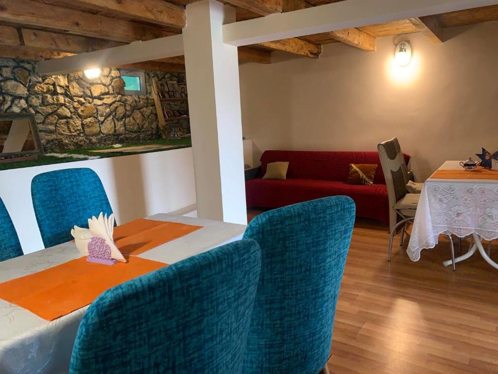 een kamer met een tafel en stoelen en een rode bank bij Tsivi Tba in Tskaltubo