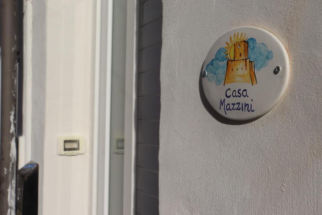 ein Schild an einer Wand mit einem Turm darauf in der Unterkunft Casa Mazzini in Termoli