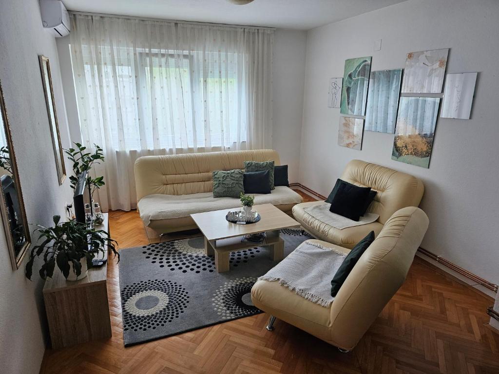 a living room with two couches and a table at Apartman Sany in Bihać