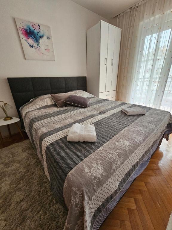 a bedroom with a large bed with two towels on it at Apartman Sany in Bihać