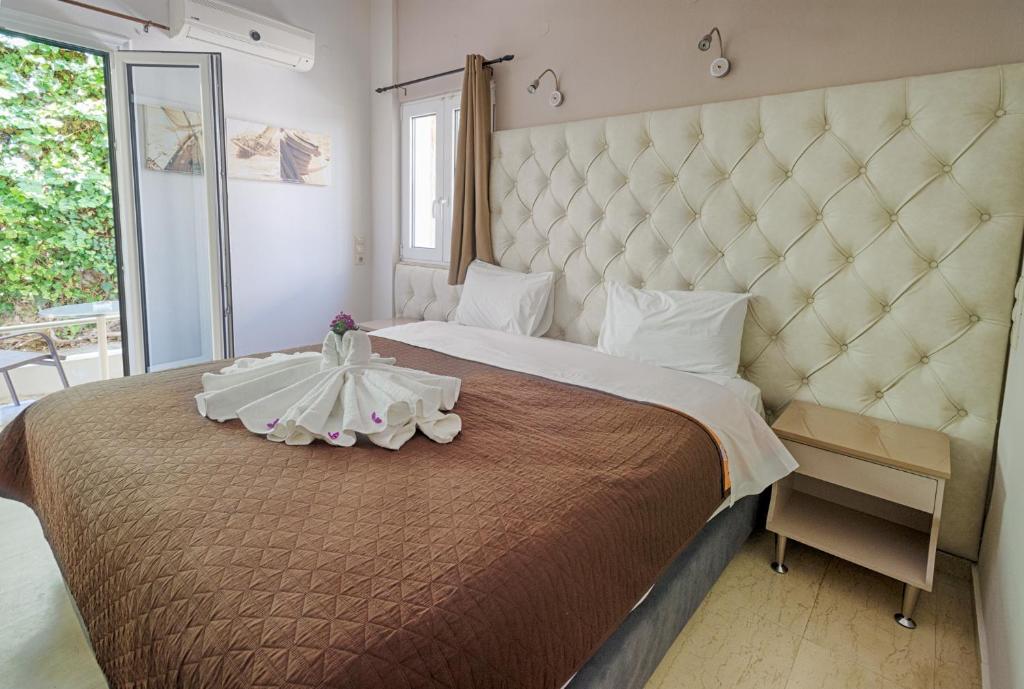 a bedroom with a large bed with a large headboard at Fantastic Matala 1 in Matala