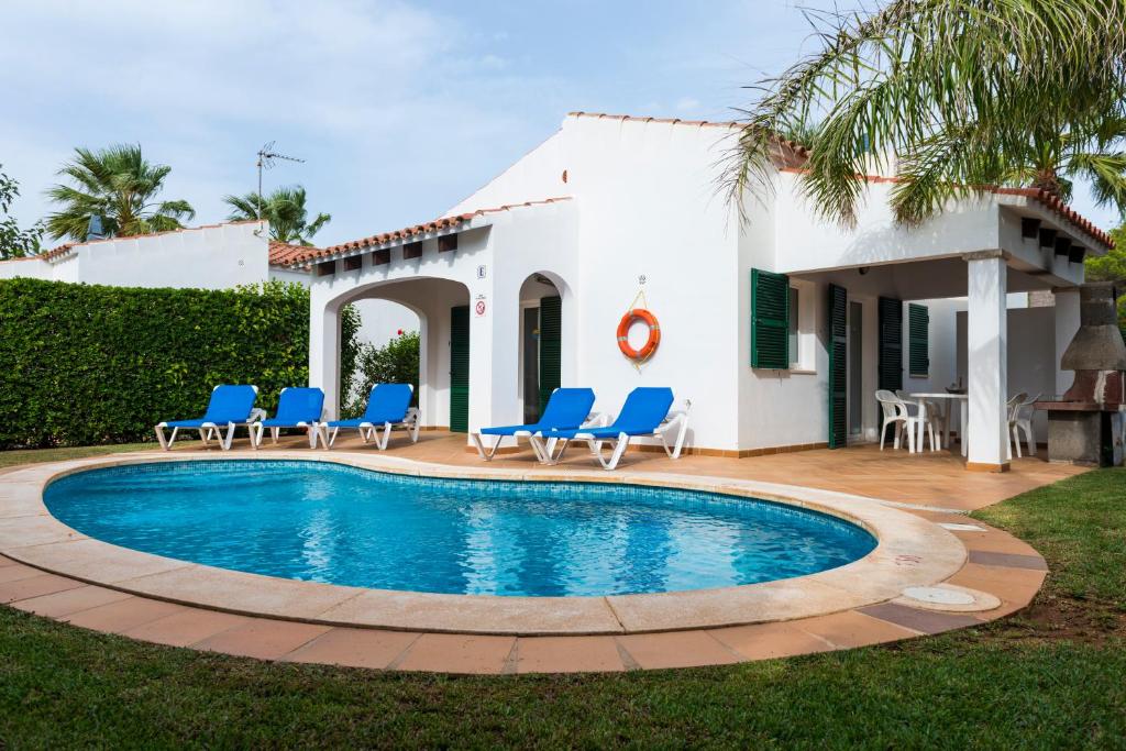 a villa with a swimming pool in front of a house at Apartchalet villas Elvira. Villa E in Son Carrio