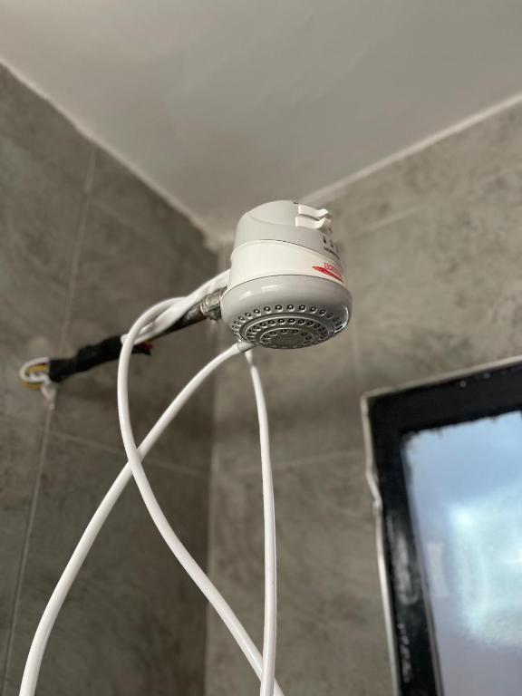 a blow dryer is hanging from the ceiling of a shower at Lulu’s staycations Tsavo in Nairobi