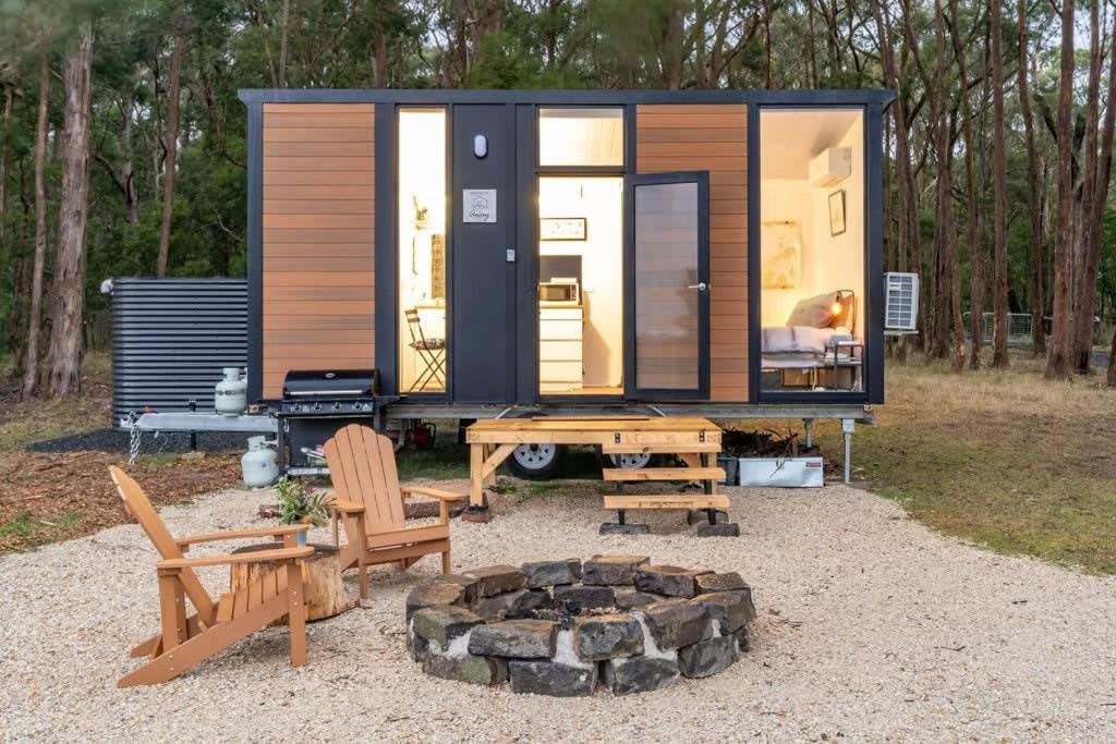 a tiny house with a picnic table and benches at Left Field Tiny House in Ashbourne